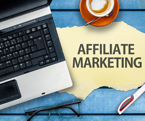 computer sitting next to a cup of coffee with a place mat that reads Affiliate Marketing